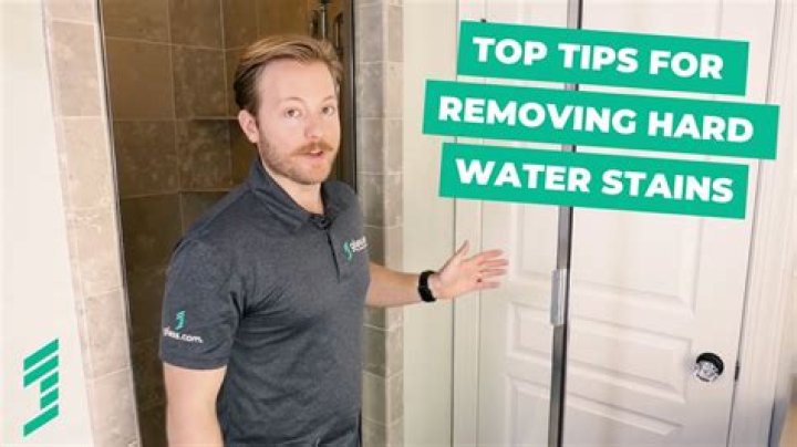How do you remove hard water stains from shower walls?